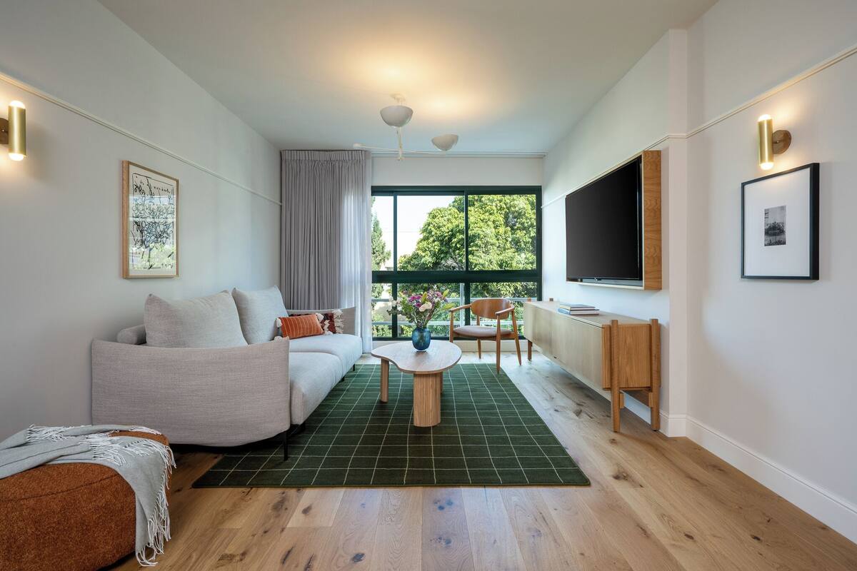 Un salon moderne avec un canapé, une table basse et un téléviseur fixé au mur.