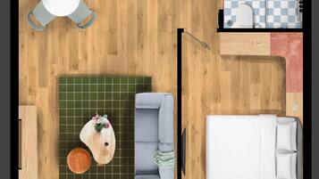 Vista cenital de una habitación con una mesa de comedor, un sofá, una cama, una pequeña cocina y un baño.