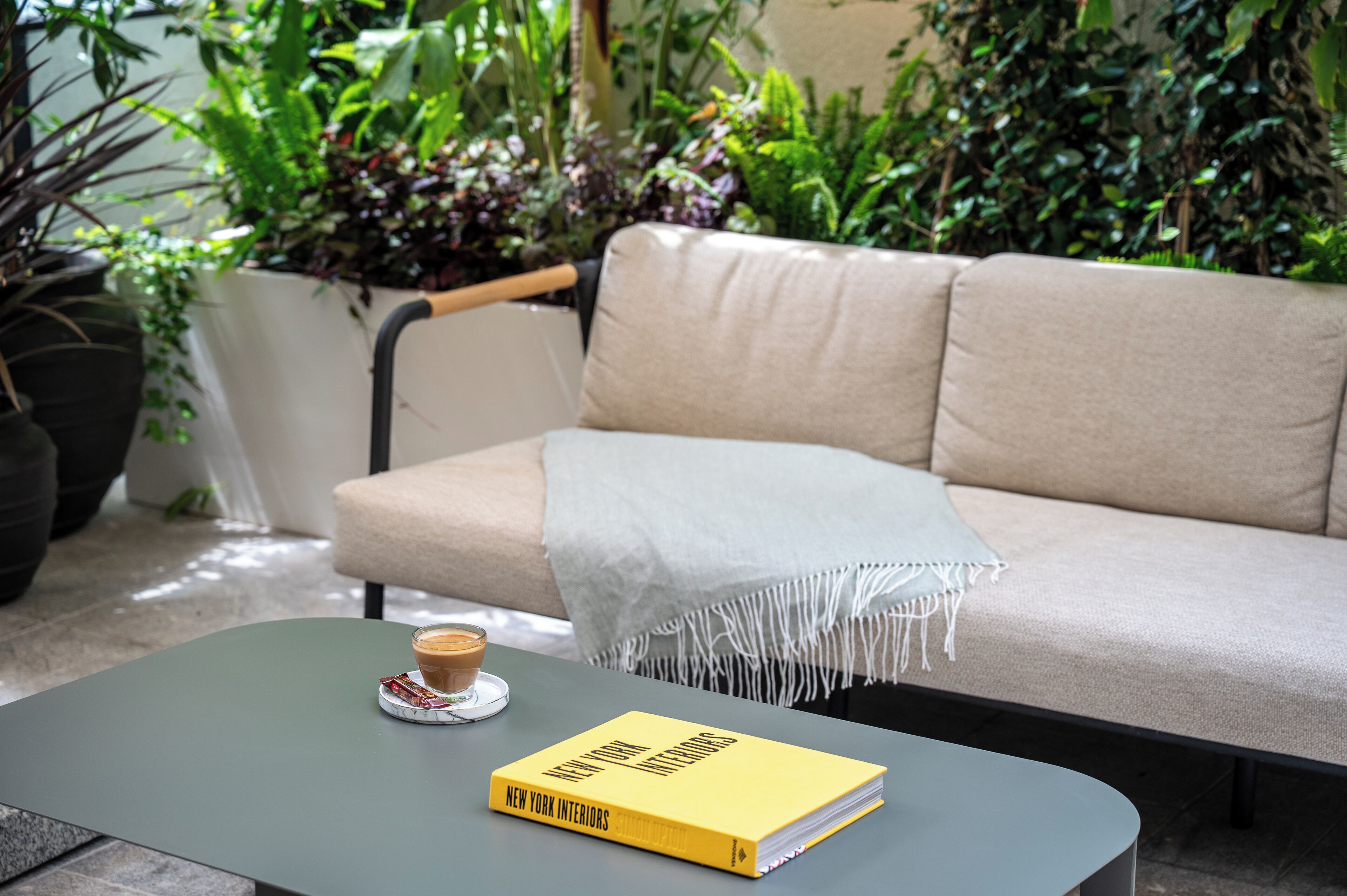Una sala de estar moderna con un sofá color beige, una mesa de centro y un libro titulado 