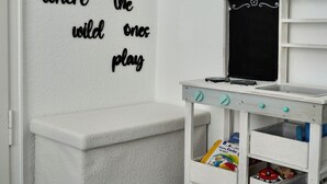 A room with a white bench, a small white table with a blackboard, and a wall with a motivational quote. - Loft & Living am Geiseltalsee (Braunsbedra)