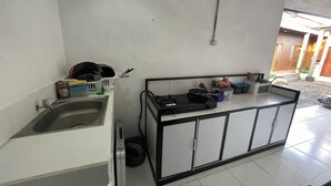 A compact kitchen with a sink, stove, and cabinets. - Zee House (Canggu)