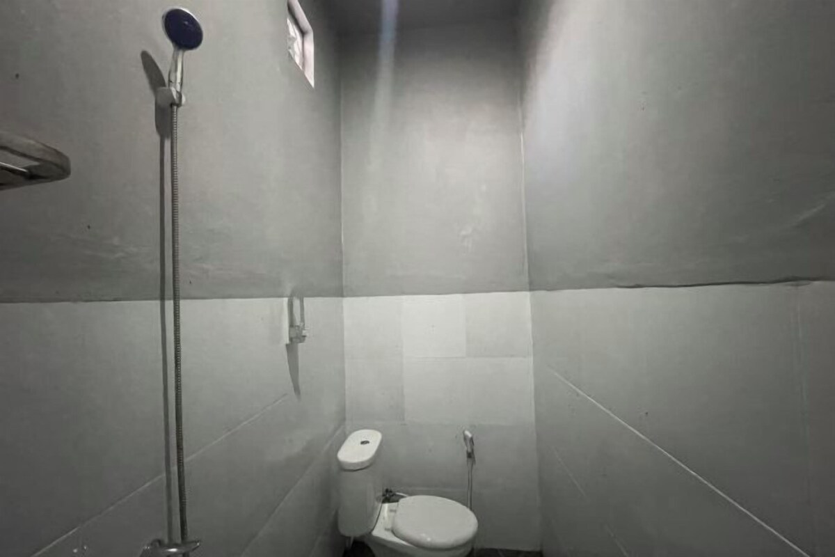 Un baño pequeño y estrecho con inodoro y ducha.