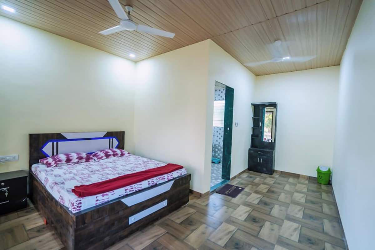 Un dormitorio con cama de madera, ventilador de techo y armario.