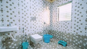 Un bagno con piastrelle a pois, un water, un lavandino e una finestra.