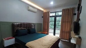 Un dormitorio con cama, mesita de noche y ventana con cortinas.