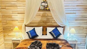 Una cama con dosel, dos lámparas de noche y dos almohadas con un diseño azul.