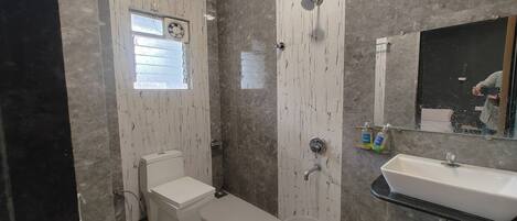 Un baño con inodoro, lavabo y ducha.