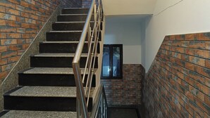 A staircase with metal railings leading to a door with a window. - Swastika Homes Near Wave City Center Noida (Noida)