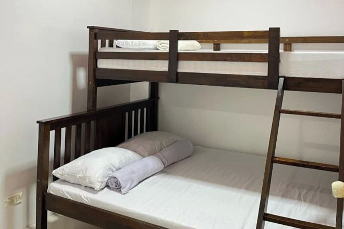 A bunk bed with a ladder, a pillow, and a folded blanket.