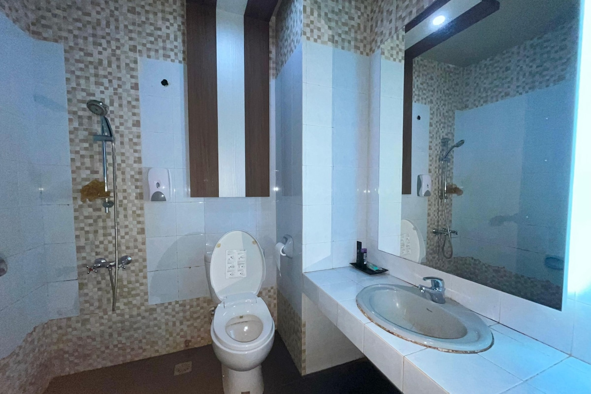 A bathroom with a toilet, a sink, and a shower.
