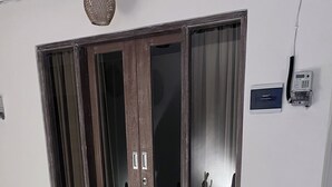 Une pièce dotée d’une porte-fenêtre coulissante, d’une chaise et d’un petit tapis.