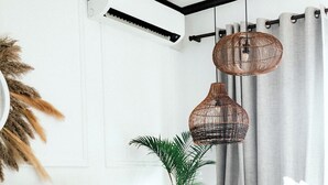 En moderne stue med en hvid sofa, et sofabord og en potteplante.