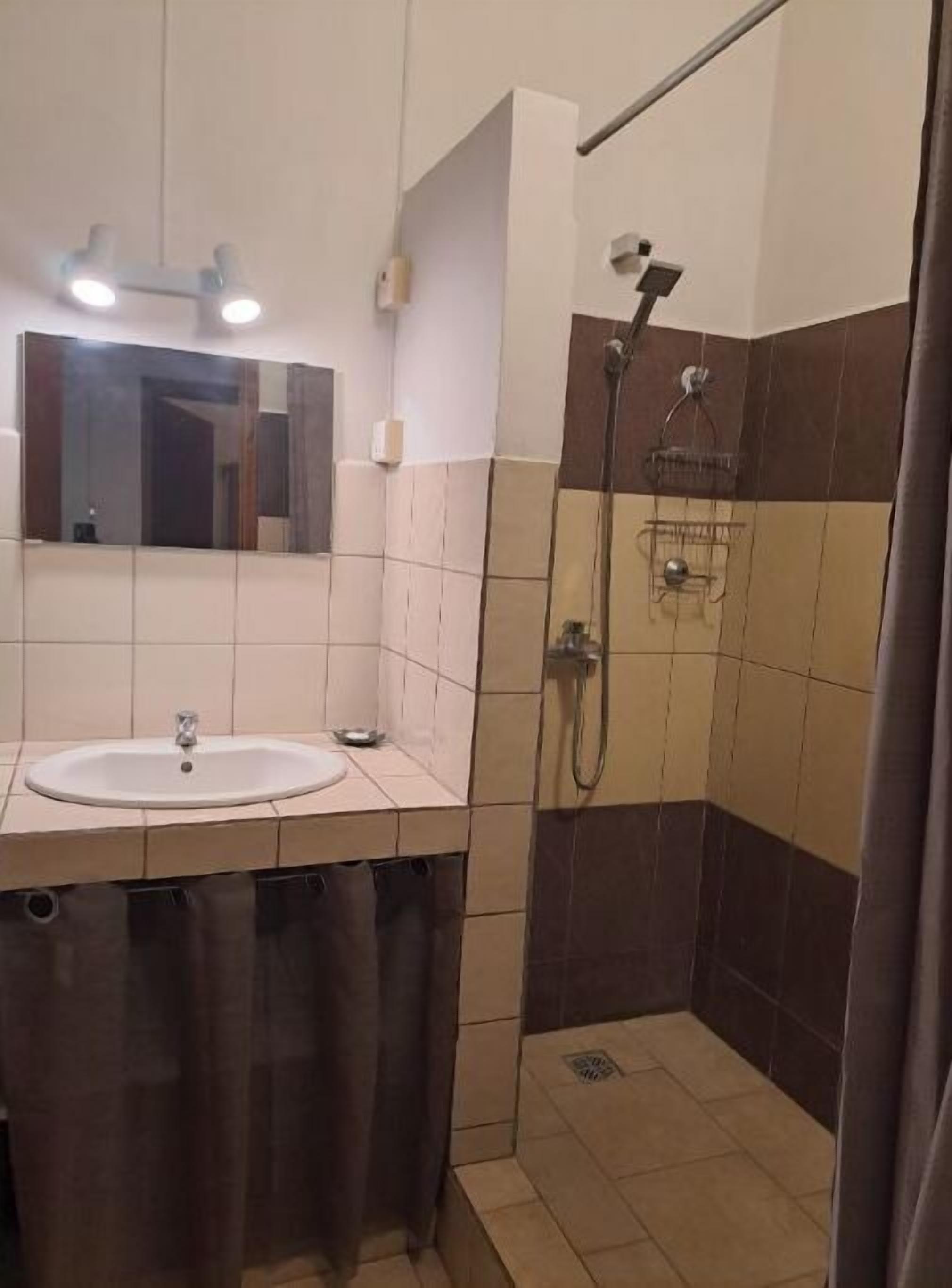 Ein Badezimmer mit Waschbecken, Spiegel und Dusche.