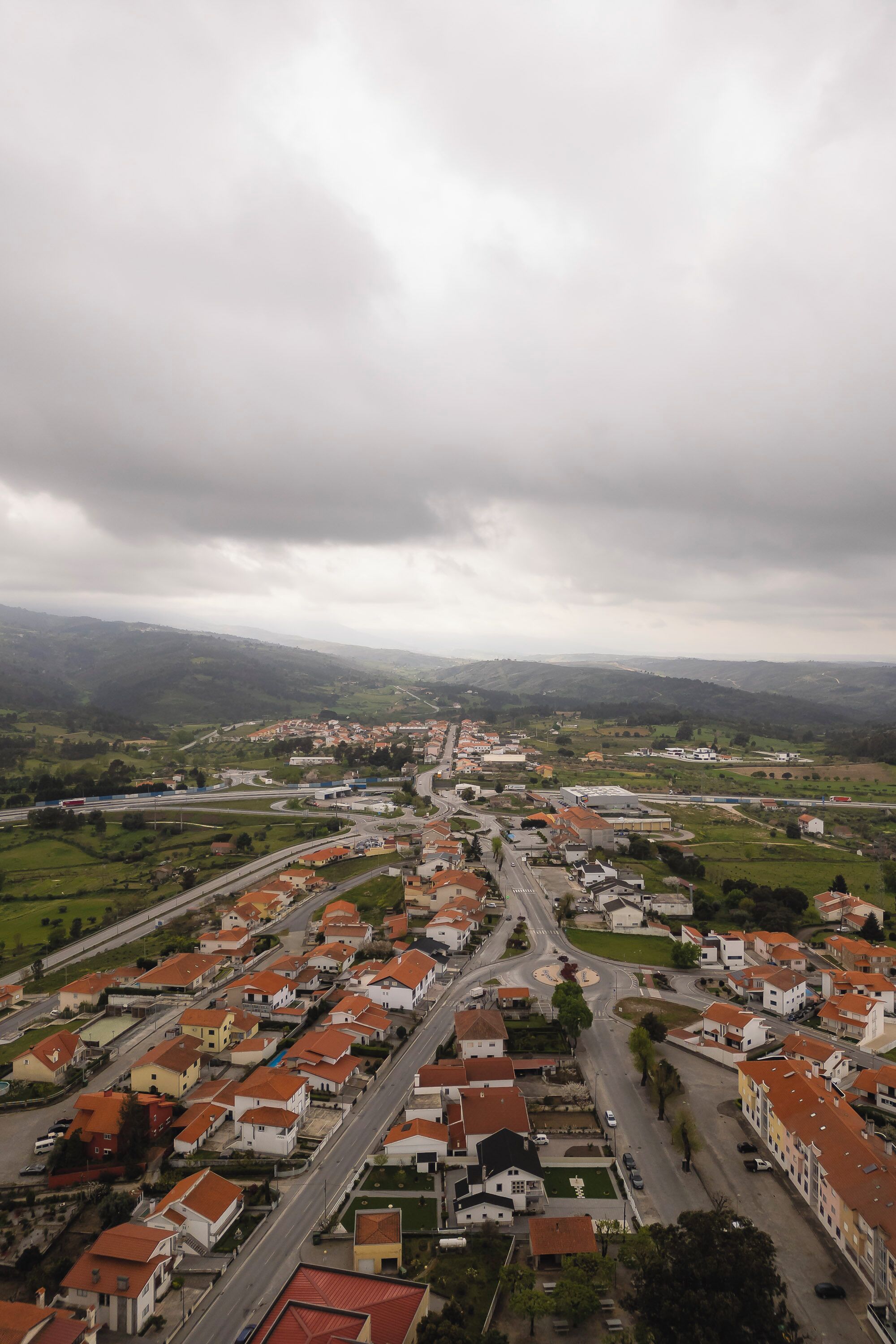 Uma área residencial com casas, ruas e uma autoestrada.