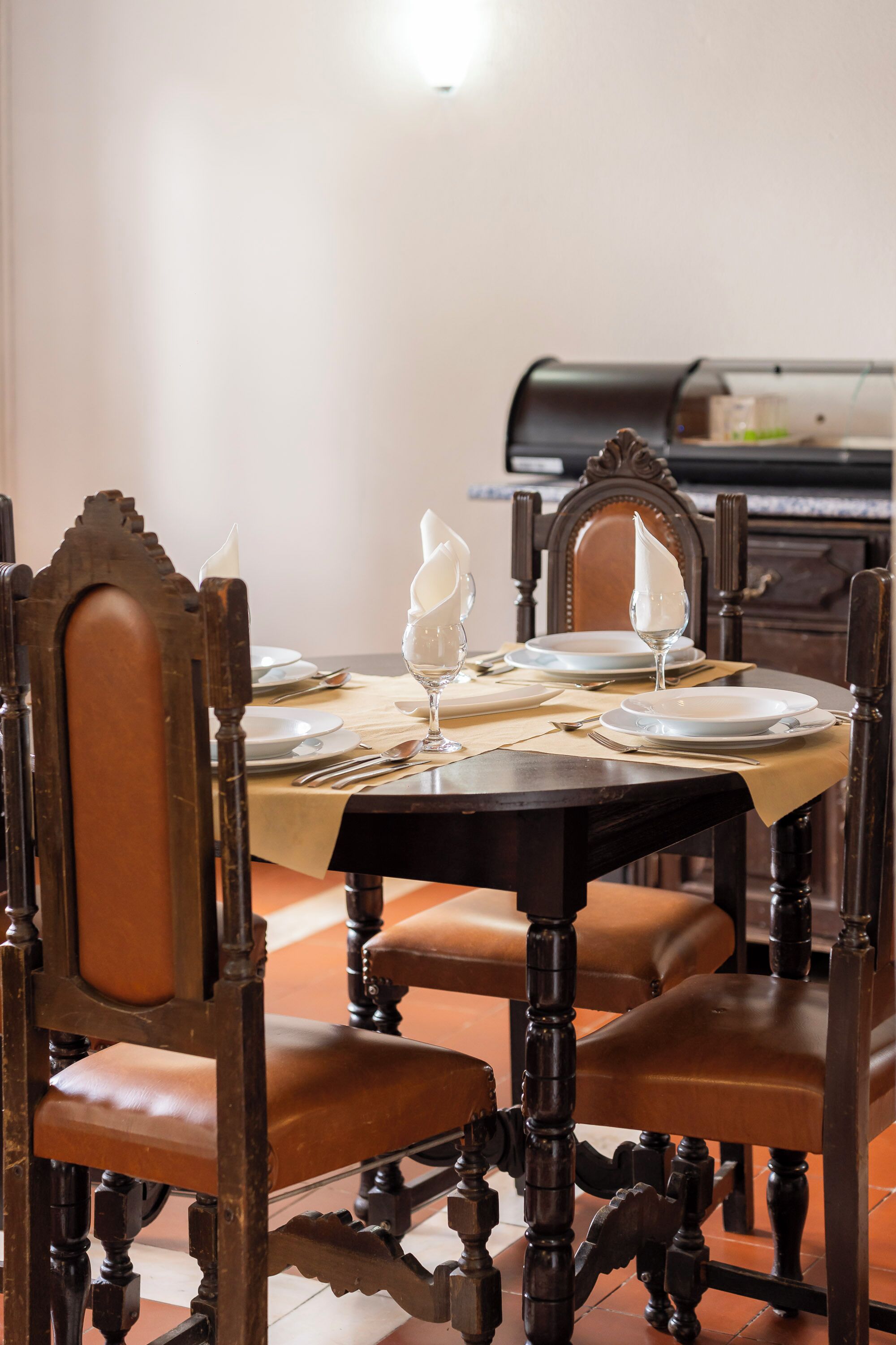 A dining table set with plates, cutlery, and a candle.