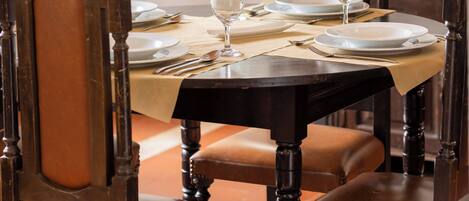 Una mesa de comedor dispuesta con platos, cubiertos y una vela.