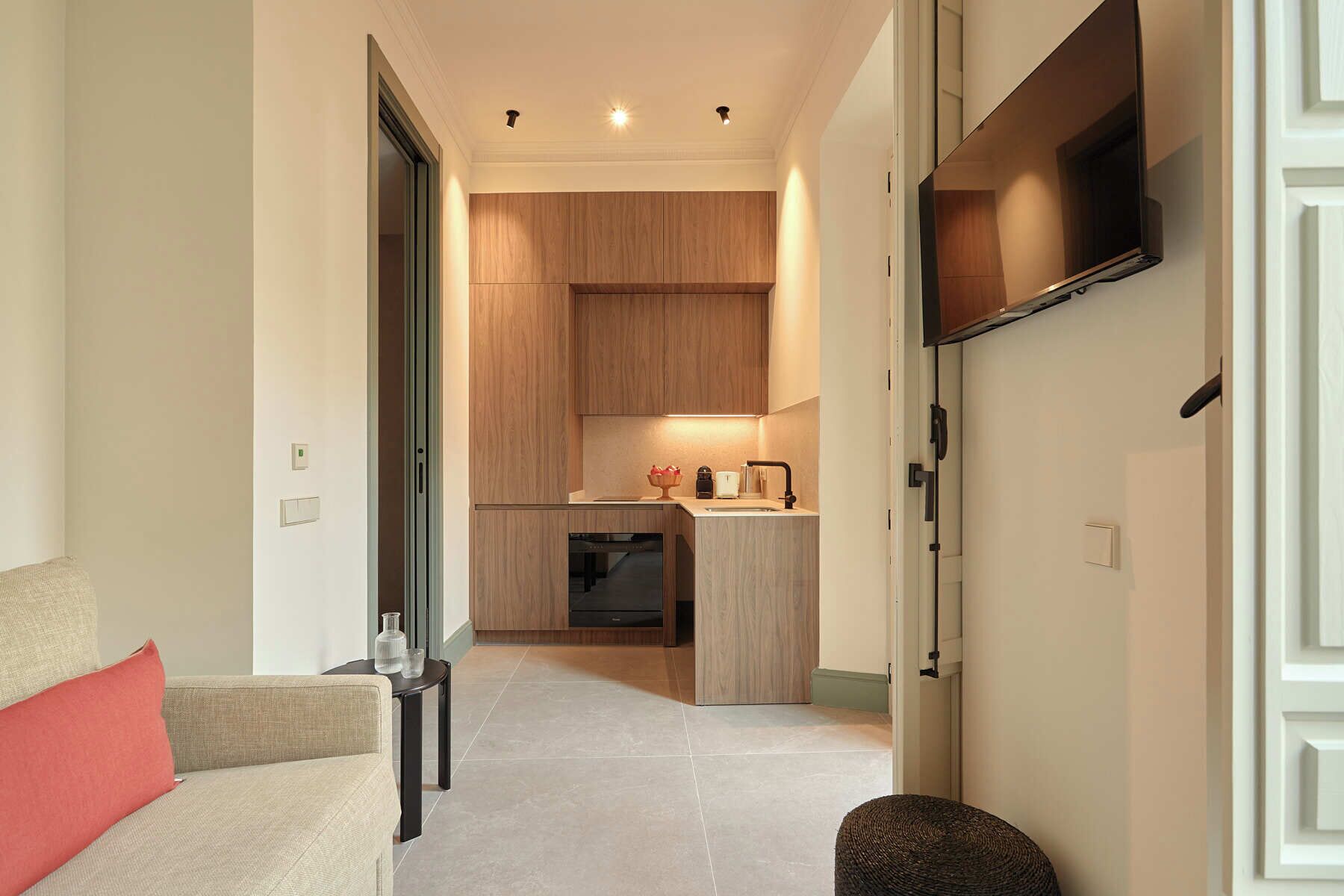 A modern kitchen with wooden cabinets, a built-in oven, and a countertop with a coffee maker and toaster.