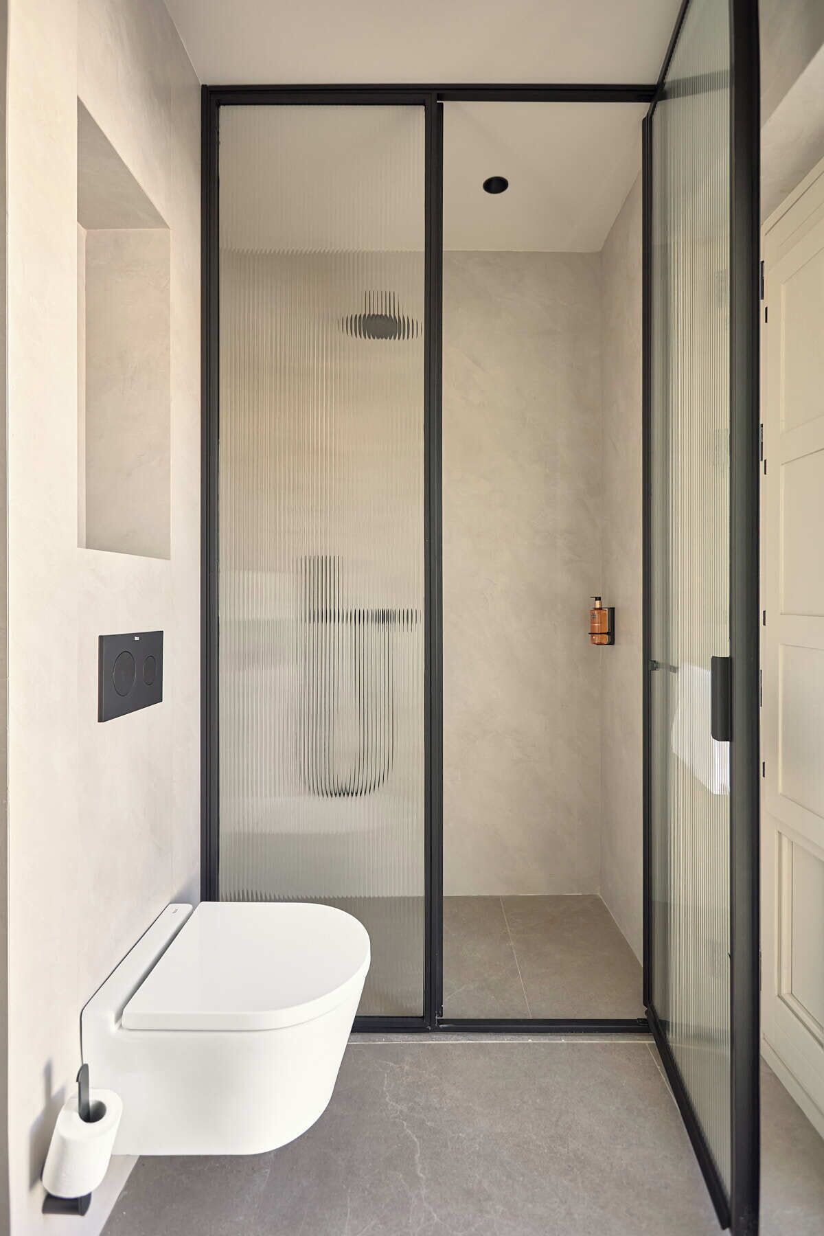 Un baño moderno con una bañera independiente, cabina de ducha con mampara de vidrio y diseño minimalista.
