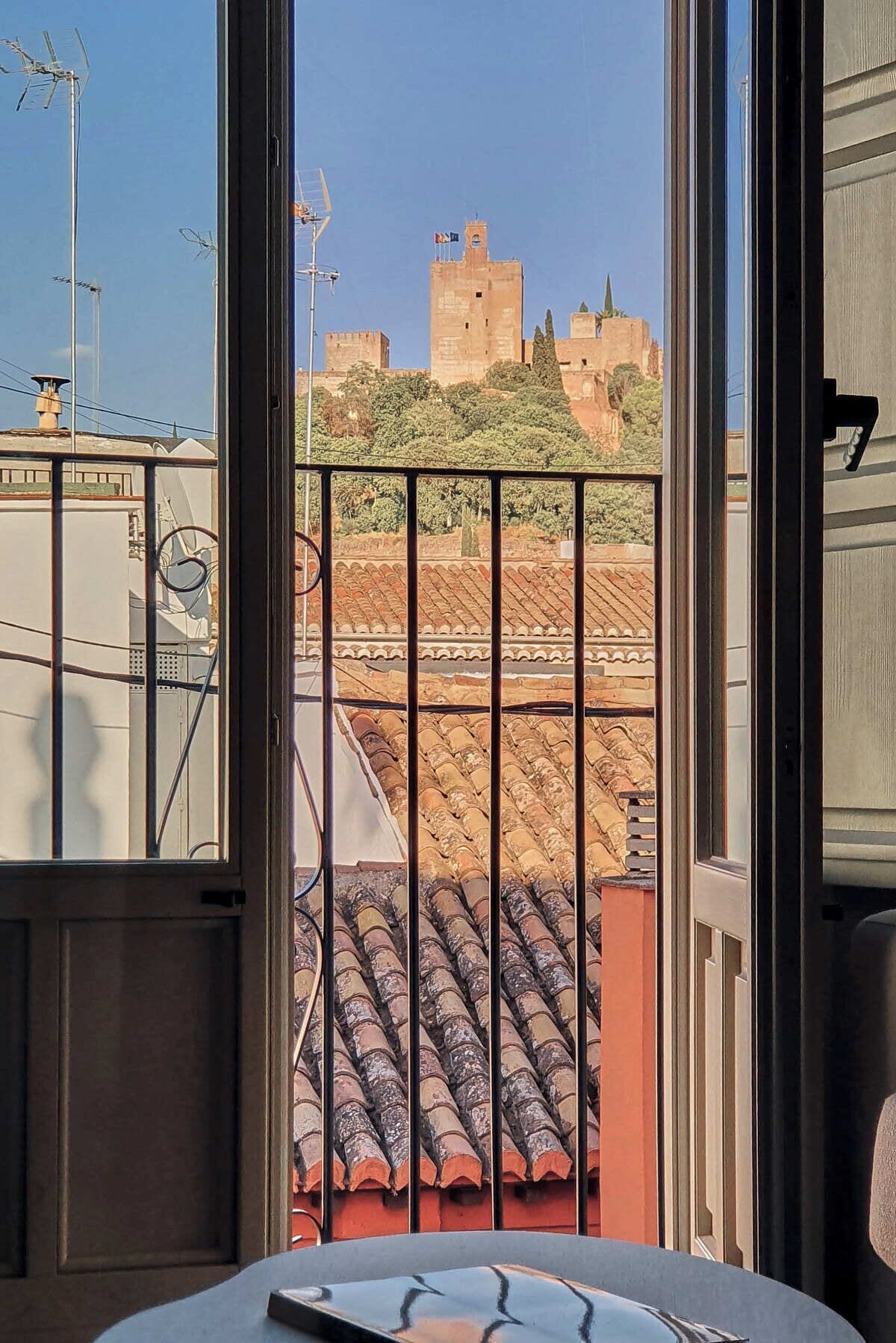 Ein Zimmer mit Blick auf ein historisches Gebäude und ein Ziegeldach.