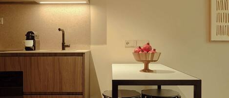 A modern kitchen with wooden cabinets, a built-in oven, and a dining area with a table and four chairs.