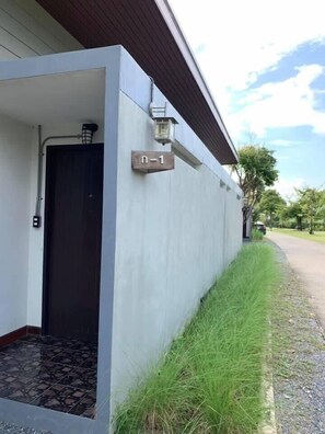 A modern building with a dark door, a small porch, and a sign reading "n-1". - Smile buffalo resort (Manorom)