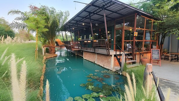 Ein Restaurant mit Pool, umgeben von üppiger Vegetation und einer überdachten Sitzgelegenheit.