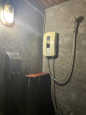 A shower area with a handheld showerhead, a wall-mounted control panel, and a bench. - Smile buffalo resort (Manorom)