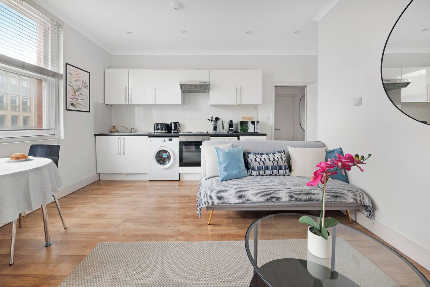 A modern apartment with a dining area, kitchen, and living space.