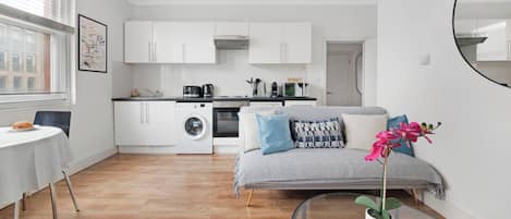 A modern apartment with a dining area, kitchen, and living space.