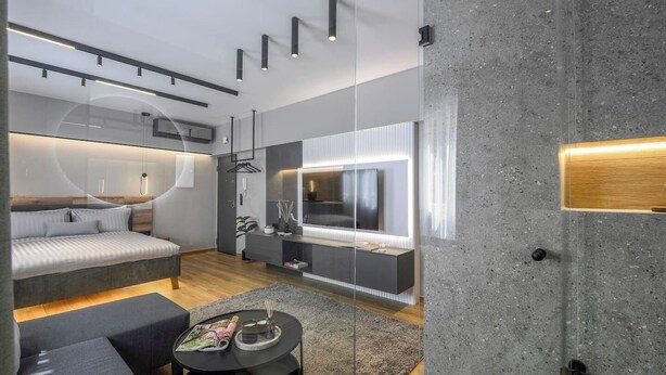 A modern living room with a sofa, a coffee table, and a TV. - Aristotelian Virtues - Enkrateia (Thessaloniki)