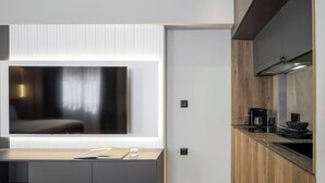 A modern kitchen with a built-in stove, a coffee machine, and a large window above the counter. - Aristotelian Virtues - Enkrateia (Thessaloniki)