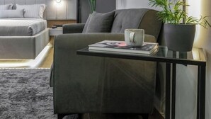 Ein modernes Schlafzimmer mit Bett, Nachttisch und einer Topfpflanze.