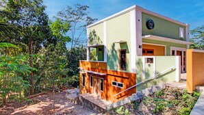 Un bâtiment moderne à deux étages, doté d’un toit plat, d’un escalier menant à l’étage supérieur et d’un petit espace porche.