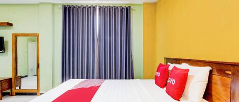 Un cuarto de hotel con una cama grande, un cabecero de madera y un espejo en la pared.