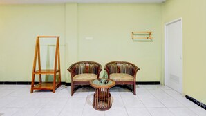 Une pièce comprenant deux chaises en bois, une petite table ronde et un grand présentoir en bois.