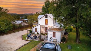 A house with a hot tub, outdoor seating, and a well-maintained lawn.