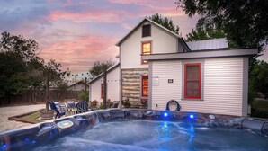 A hot tub with a stone facade house in the background.