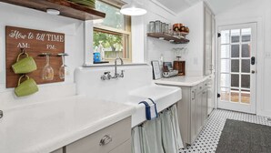 A kitchen with a sink, a window, and a door.