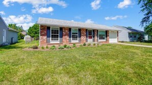 A single-story house with a brick facade, a front porch, and a well-maintained lawn. - Retro Refuge On Woodstock Dr. (Van Wert)