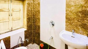 Casa de banho com sanita, bidé e lavatório.