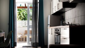 Una cocina moderna con horno empotrado y comedor con mesa y sillas.