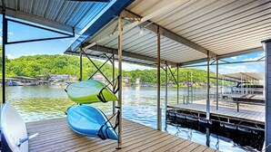 A wooden deck with kayaks and a satellite dish. - The Lake Shack Waterfront Life (Camdenton)