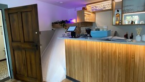 A modern kitchen with a wooden counter, a bar area with glassware, and a computer monitor. - Hostel  Altes Spital Balingen (Balingen)
