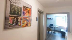 A hallway with a wall decorated with various artworks. There is a door leading to a room with a table and chairs. - Hostel  Altes Spital Balingen (Balingen)