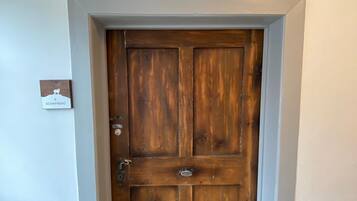 A wooden door with a nameplate reading "SCHAFBERG" in a hallway with white walls and a carpeted floor.