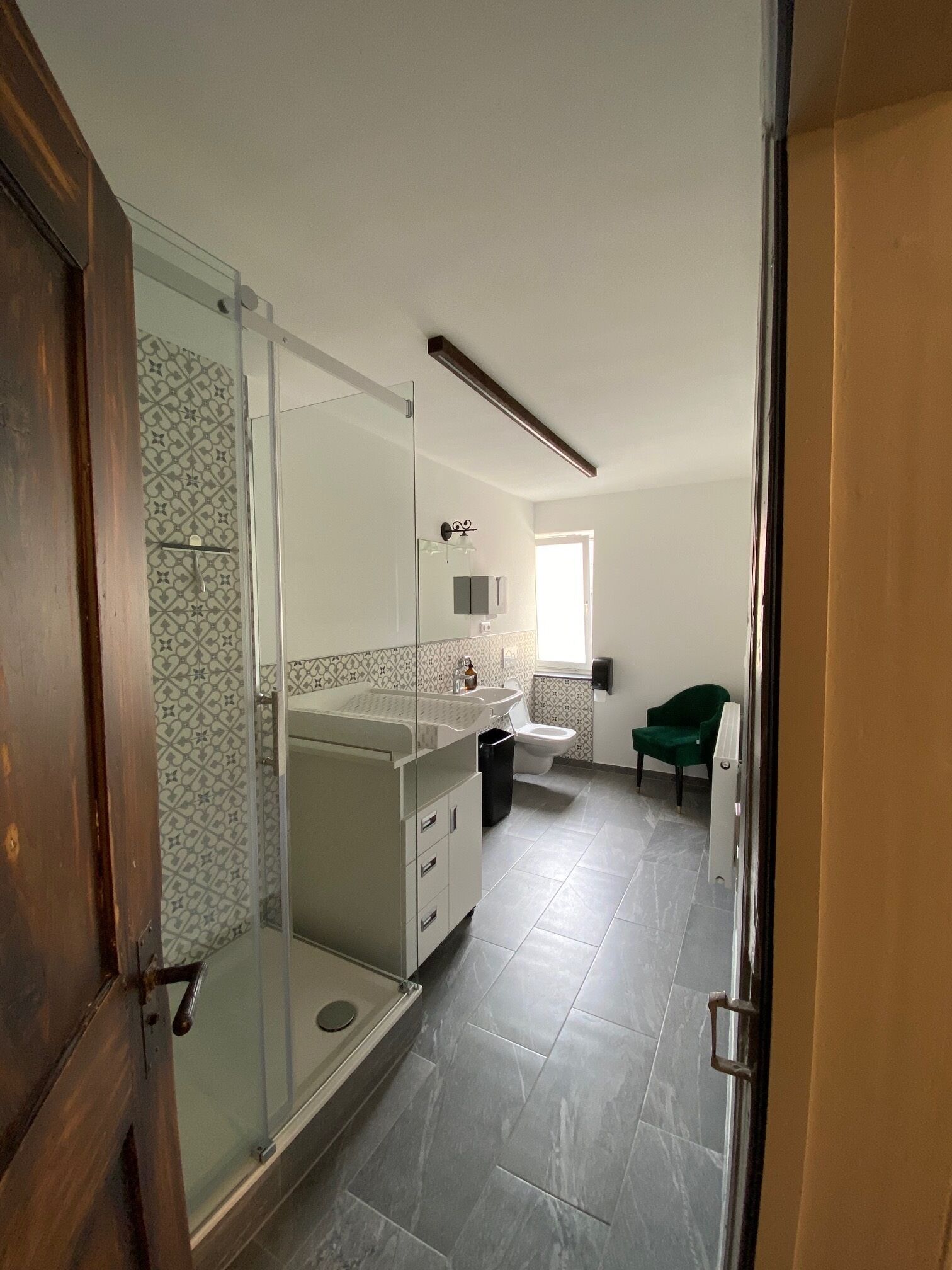 A modern bathroom with a glass shower enclosure, a vanity with a mirror, and a toilet.