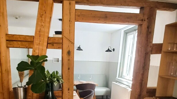 A wooden dining area with a table, chairs, and a potted plant. - Hostel  Altes Spital Balingen (Balingen)