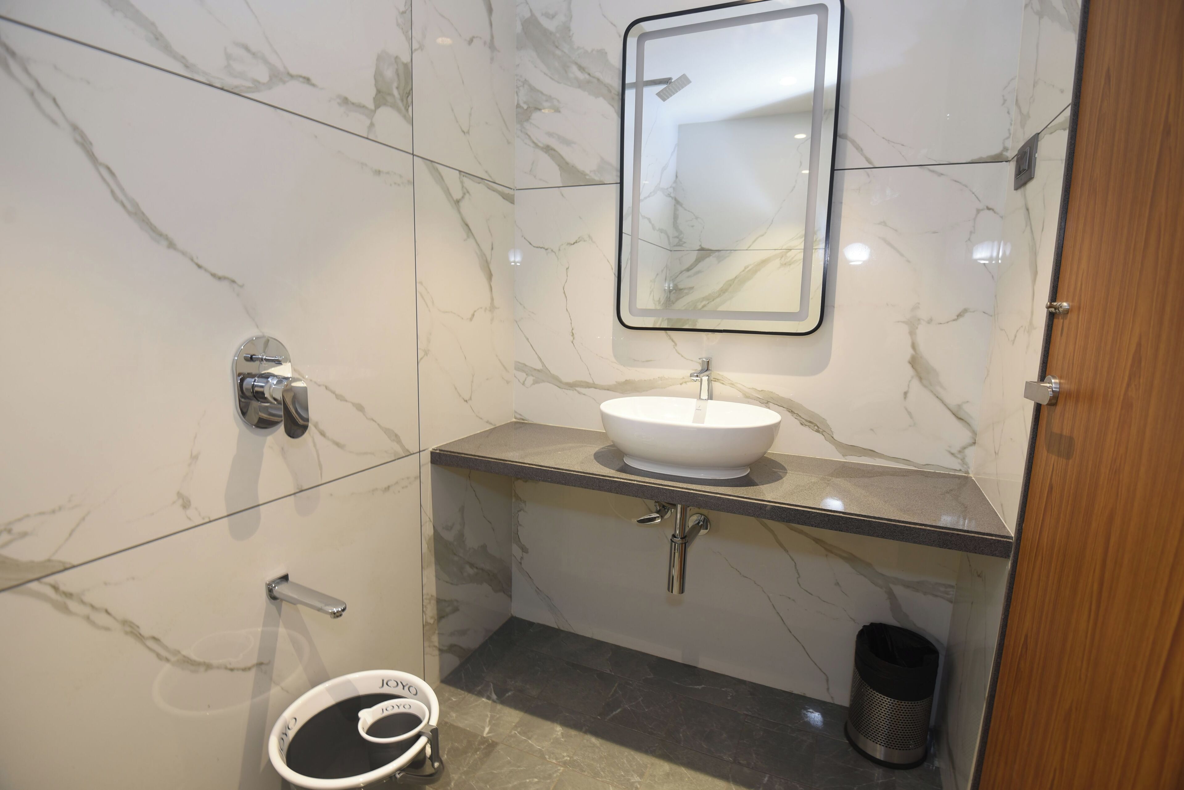 A bathroom with a white marble sink, chrome fixtures, and a mirror.