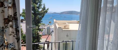 A balcony with a view of the sea and boats.