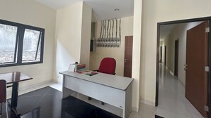Una oficina moderna con un escritorio, una silla y un ventanal.